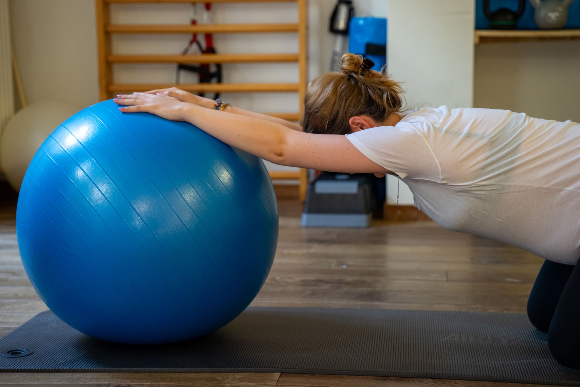 Kinesitherapeut begeleidt een oefening met de grote fitbal