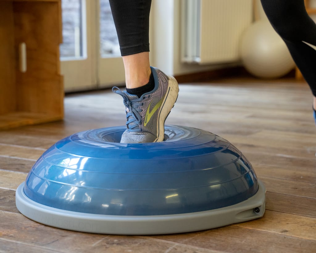 Evenwichtsoefening met één voet op een balanstrainer
